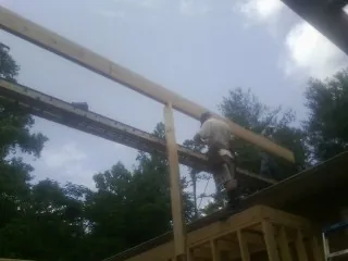 Carpenter setting a ridge beam over a new addition frame — Ice Dam Removal by Roofing Brothers in East Waterboro
