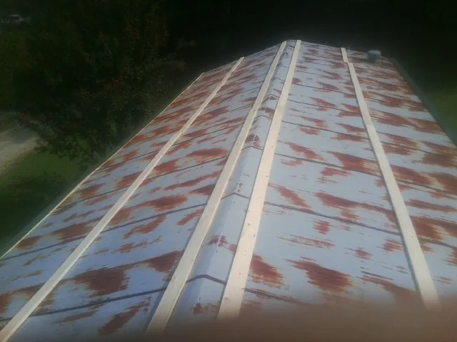 Rusted metal roof panels with new wood purlins before replacement — Storm Damage Roof Repair in East Waterboro by Roofing Brothers