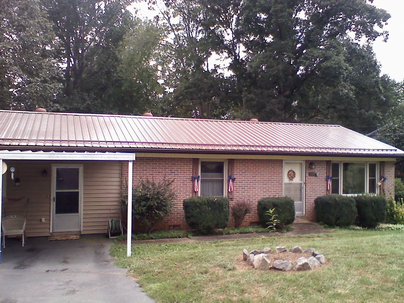 Bronze metal roof and carport on a brick ranch home — Roof Repair work by our crew in East Waterboro